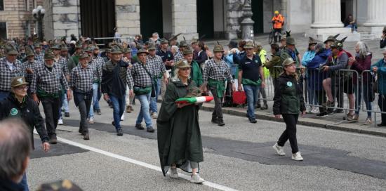 Una Alpina sfila tenendo in mano un cuscinetto tricolore con sopra il tipico cappello con la penna Una Alpina sfila tenendo in mano un cuscinetto tricolore con sopra il tipico cappello con la penna