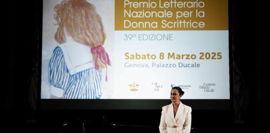 La conduttrice Roberta Capua, dietro a lei il maxischermo con la locandina dell'evento