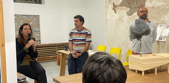 l'assessore Rosso parla al microfono all'interno della falegnameria
