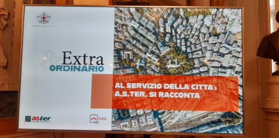 schermo con titolo convegno e immagine aerea città 