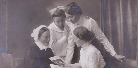 foto di un gruppo d quattro donne che guardano un libro