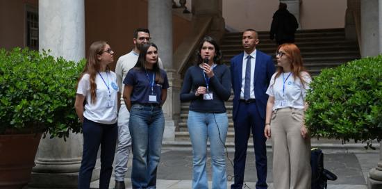 Il consigliere Kaabour accanto ad alcune ragazze e ragazzi nel cortile di Palazzo Tursi
