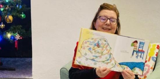 educatrice che legge e illustra favola di Natale