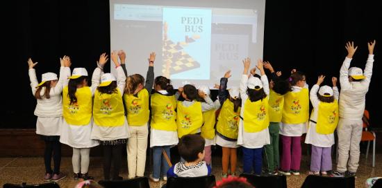 Bimbe e bimbi con cappellini e pettorine sul palco del teatro Iqbal