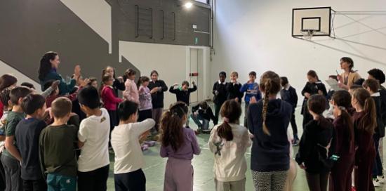 Bimbi in piedi in palestra durante uno dei laboratori della giornata
