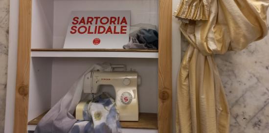 macchina da cucire e cartello sartoria solidale 