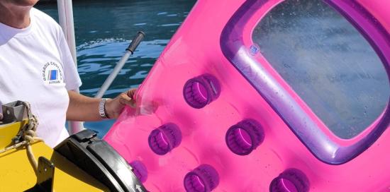 Uno dei volontari a bordo di un battello mostra un materassino di plastica raccolto in mare