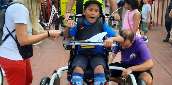 Un bimbo disabile sulla bici speciale attrezzata per il trasporto delle persone in carrozzina