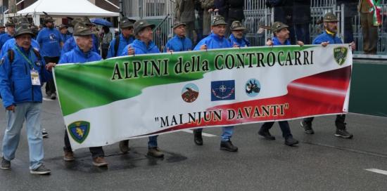 Alpini sfilano con lo striscione "Alpini della Controcarri: mai njun davanti"