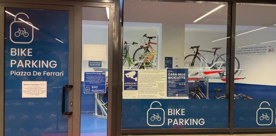 Foto a campo largo dell'ingresso del Bike Parking: insegna e "vetrina" con dentro le prime bici parcheggiate