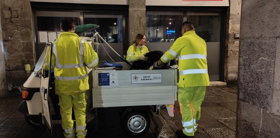 Operatori di Amiu impegnati a scaricare materiali vari da un ciclocarro
