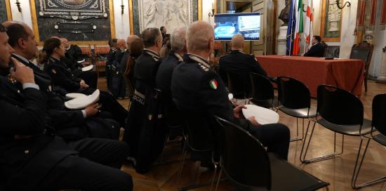 Gli agenti in platea guardano un video trasmesso sullo schermo del Salone