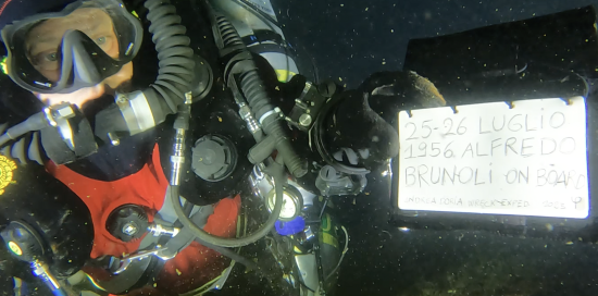  David D'anna, nipote di un superstite del naufragio mostra il taccuino sott'acqua in ricordo del giorno dell'affondamento dell'