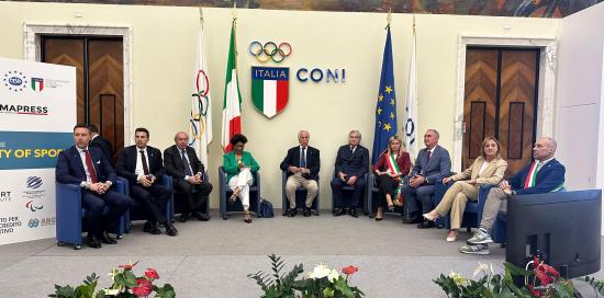relatori seduti in semicerchio sullo sfondo bandiera CONI