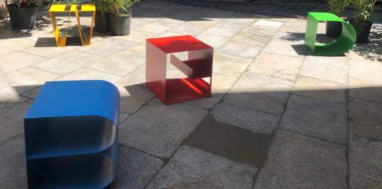 tavolini di design colorati all'esterno di palazzo