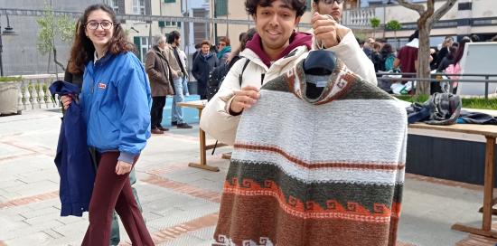Un ragazzo mostra il vestito appena scambiato con un altro partecipante allo "swap party"