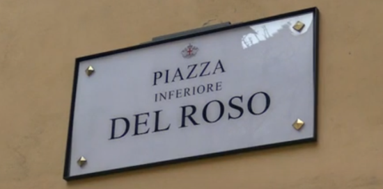 Targa toponomastica della piazza, bianca con la cornice nera e la scritta "Piazza Inferiore del Roso" al centro