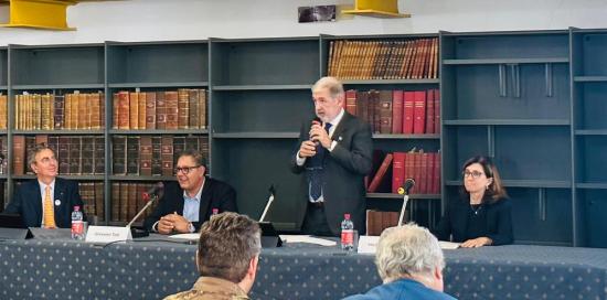 Bucci in piedi parla al microfono, seduti Beppe Costa e Giovanni Toti