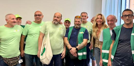 La sindaca Salis insieme ad alcuni lavoratori del progetto StarTappe, tutti con la maglia verde