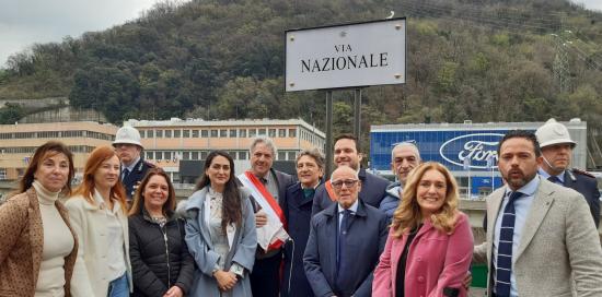 Gruppo con autorità davanti alla nuova targa