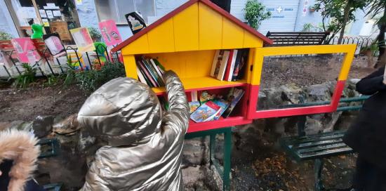 Una bimba inserisce il suo libro nella casetta