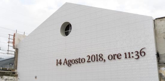 La facciata esterna del Memoriale con la scritta "14 agosto 2018, ore 11:36" su sfondo bianco