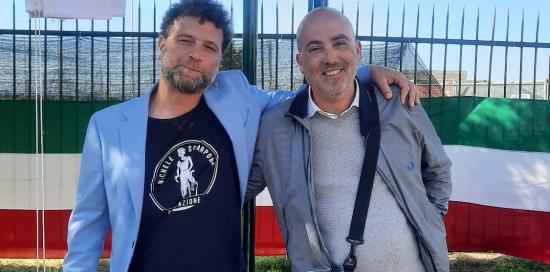 Marco Scarponi e Luca Rinaldi, fratello di Michele Scarponi e figlio di Rocco Rinaldi, abbracciati sotto la targa inaugurata