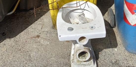 Un bidet appoggiato su un bidoncino per la raccolta della plastica