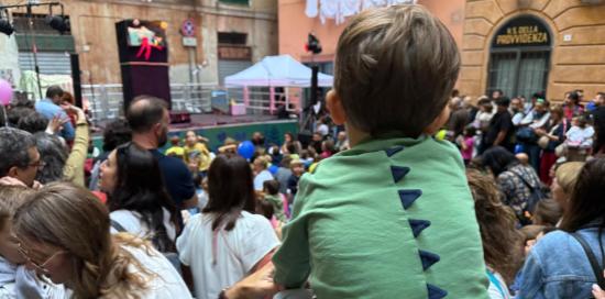 Un bimbo sulle spalle del papà in mezzo alla festa in piazza della Cernaia