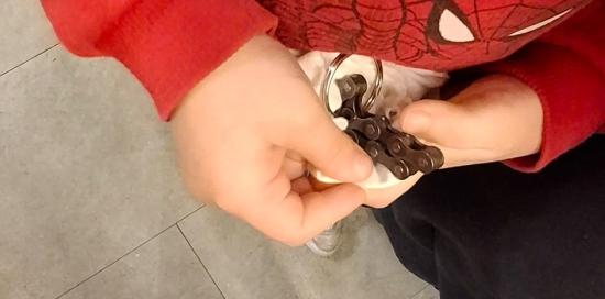 Uno dei bimbi della Monticelli impegnato a realizzare un gadget con le catene di biciclette 