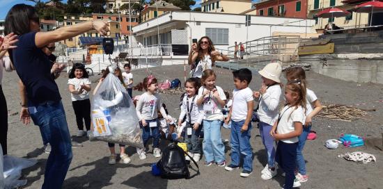 animatrice mostra il sacco con i rifiuti raccolti in spiaggia
