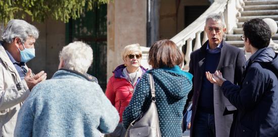 persone conversano con assessore Garassino all'esterno della villa
