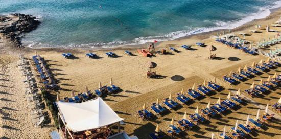 veduta dall'alto di una spiaggia attrezzata con file di lettini e sdraio