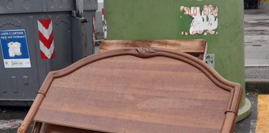 La testata di un letto appoggiata accanto a una campana del vetro