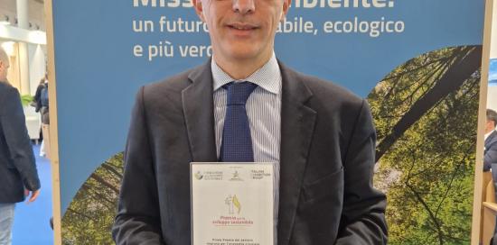 Assessore Campora con in mano il primo premio per l'economia circolare