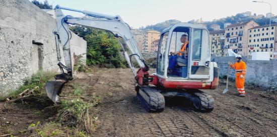 Una "ruspetta" impegnata nei lavori di sgombero della vegetazione arbustiva insistente sull'area. Al suo fianco un operaio.