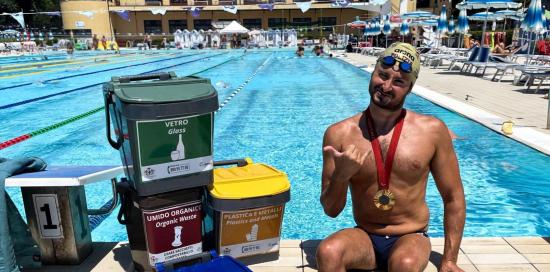 Francesco Bocciardo, a bordo vasca, accanto ad alcuni piccoli contenitori per la raccolta differenziata
