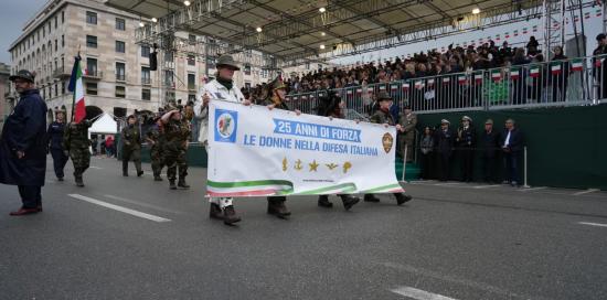 Alpine sfilano con lo striscione "25 anni di forza: le donne nella difesa italiana"