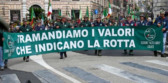 Alpini sfilano dietro allo striscione "Tramandiamo i valori che indicano la rotta"