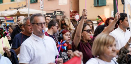 Un momento del corteo del Disability Pride: manifestanti con fischietto e cartelli, al centro la sindaca Salis