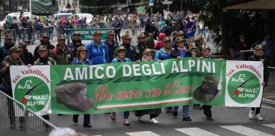 Alpini sfilano dietro allo striscione "Amico degli Alpini"