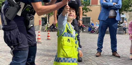 agente di polizia guida un bimbo nell'uso della paletta