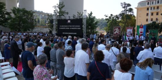 Un momento della commemorazione: il pubblico in piedi per onorare le 43 vittime Un momento della commemorazione: il pubblico in piedi per onorare le 43 vittime