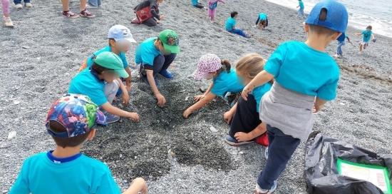 Bimbe e bimbi a "caccia" di rifiuti nella sabbia della spiaggia
