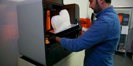 operatore estrae la copia del corpo del violino dalla stampante in 3d