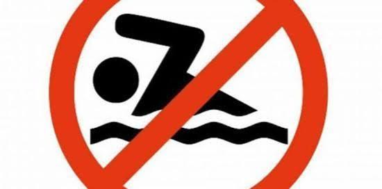 Cartello di divieto di balneazione: un bagnante stilizzato in nero dentro un "vietato" con bordo rosso e sfondo bianco