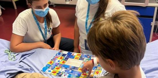 Due volontrie della Fondazione fanno giocare un bimbo in una stanza di ospedale Due volontrie della Fondazione fanno giocare un bimbo in una stanza di ospedale