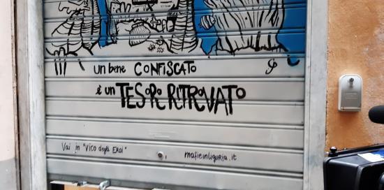Saracinesca abbassata di un locale con scritto "Un bene confiscato è un tesoro ritrovato"
