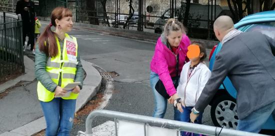Una coppia di genitori lascia la propria bambina a una volontaria presso il point "kiss and go" 