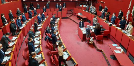 la sala rossa con i consiglieri in piedi durante il minuto di silenzio